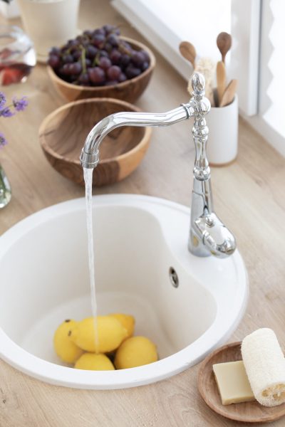 The girl washes lemons in the kitchen. Making a refreshing summer drink. Healthy food concept The girl washes lemons in the kitchen. Making a refreshing summer drink. Healthy food concept.